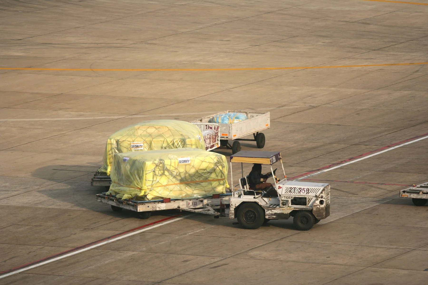 Secured cargo pallets being moved across an airport apron